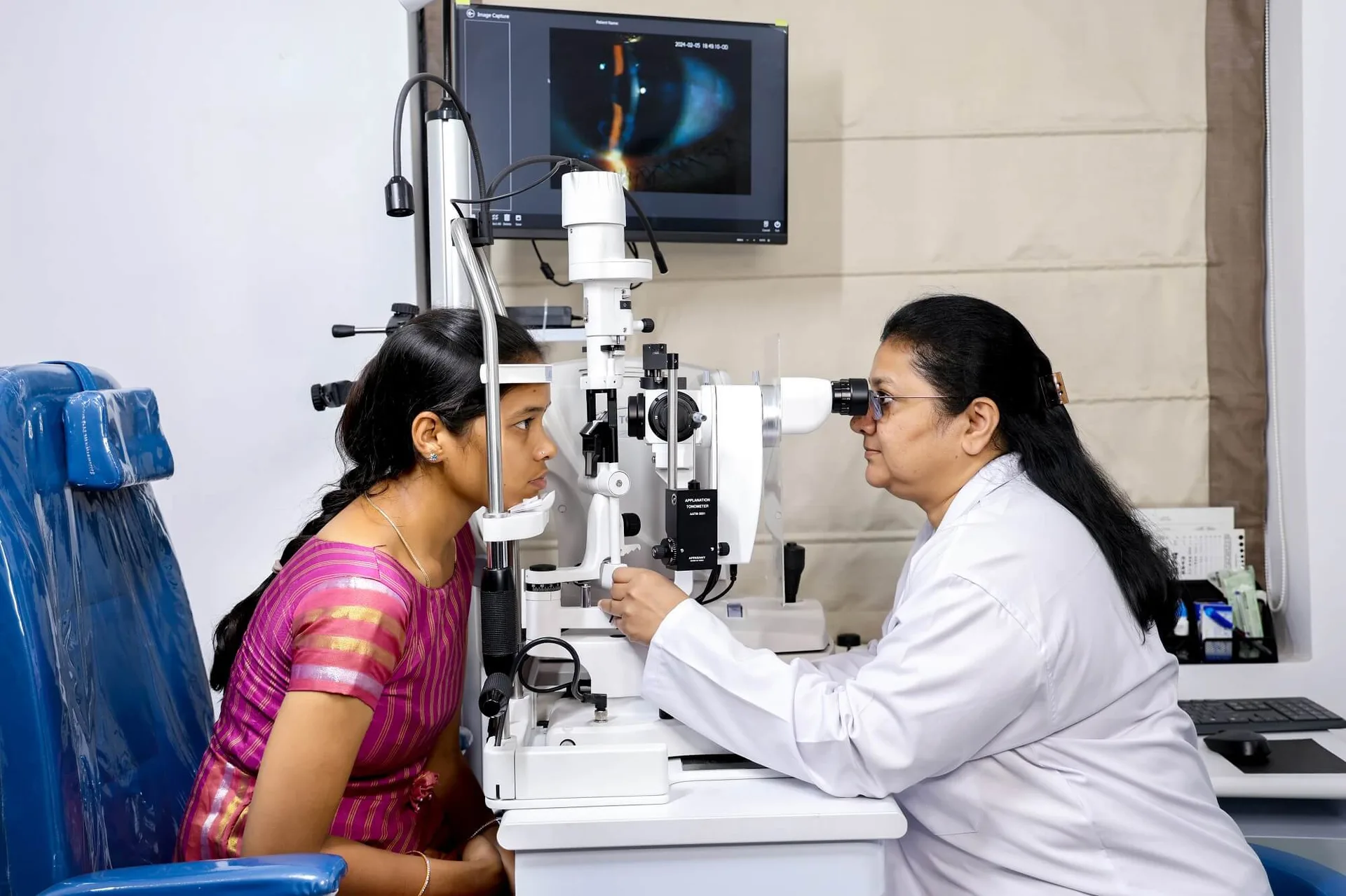 Dr. Alpa Atul Poorabia examining a patient's eyes on a slit lamp